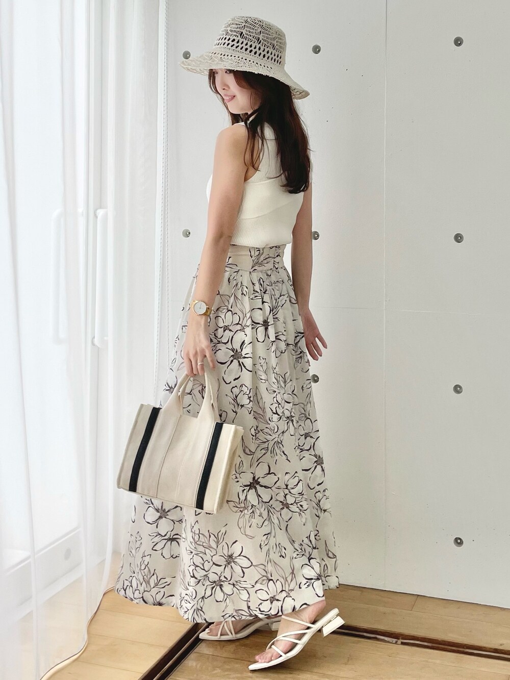 ホワイト系のニット/セーター、ホワイト系のスカート、ホワイト系のサンダルを着用したレディースの春コーディネートの3枚目の写真