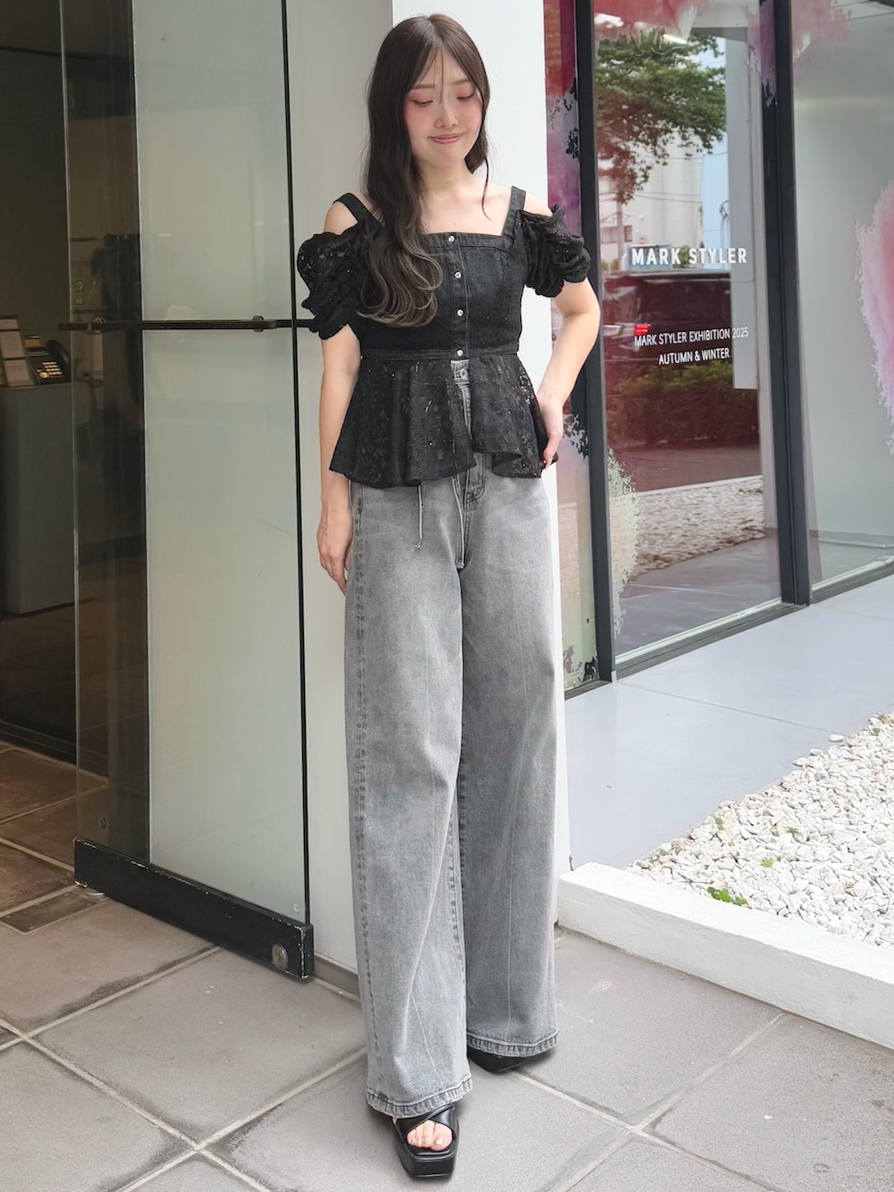 グレー系のデニムパンツ、ブラック系のサンダル、ブラック系のシャツ/ブラウスを着用したレディースの夏コーディネートの2枚目の写真