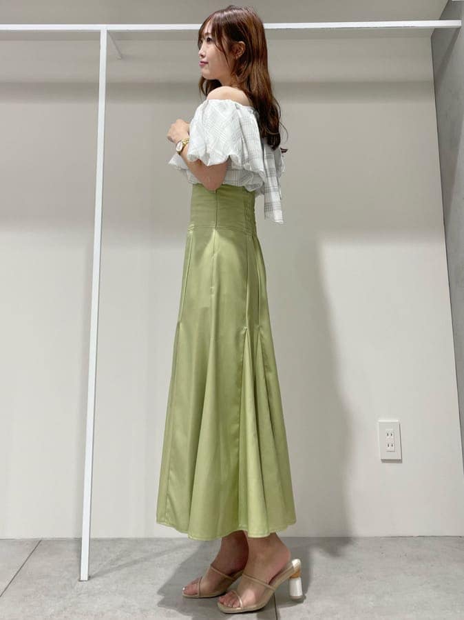 ホワイト系のキャミソール、グリーン系のスカート、ベージュ系のサンダルを着用したレディースの夏コーディネートの4枚目の写真