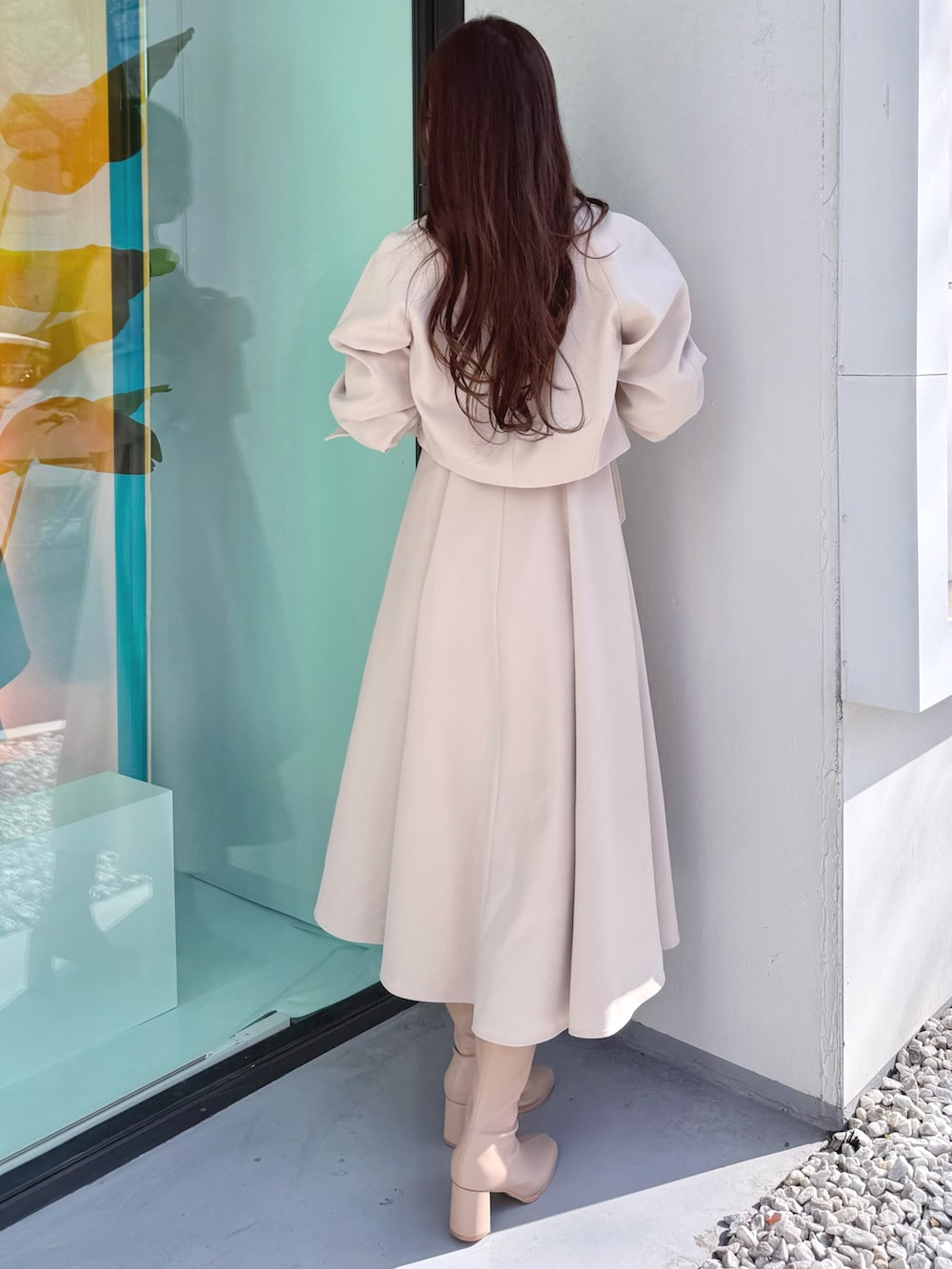 ベージュ系のワンピース、ベージュ系のブーツ、ベージュ系のトレンチコートを着用したレディースの冬コーディネートの3枚目の写真