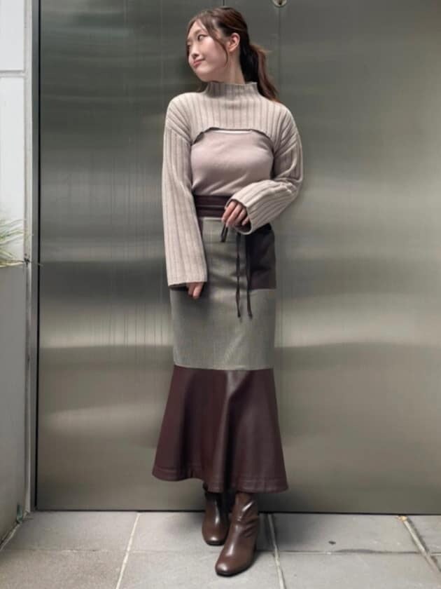 ブラウン系のブーツ、その他のスカート、ベージュ系のニット/セーターを着用したレディースの秋コーディネートの6枚目の写真