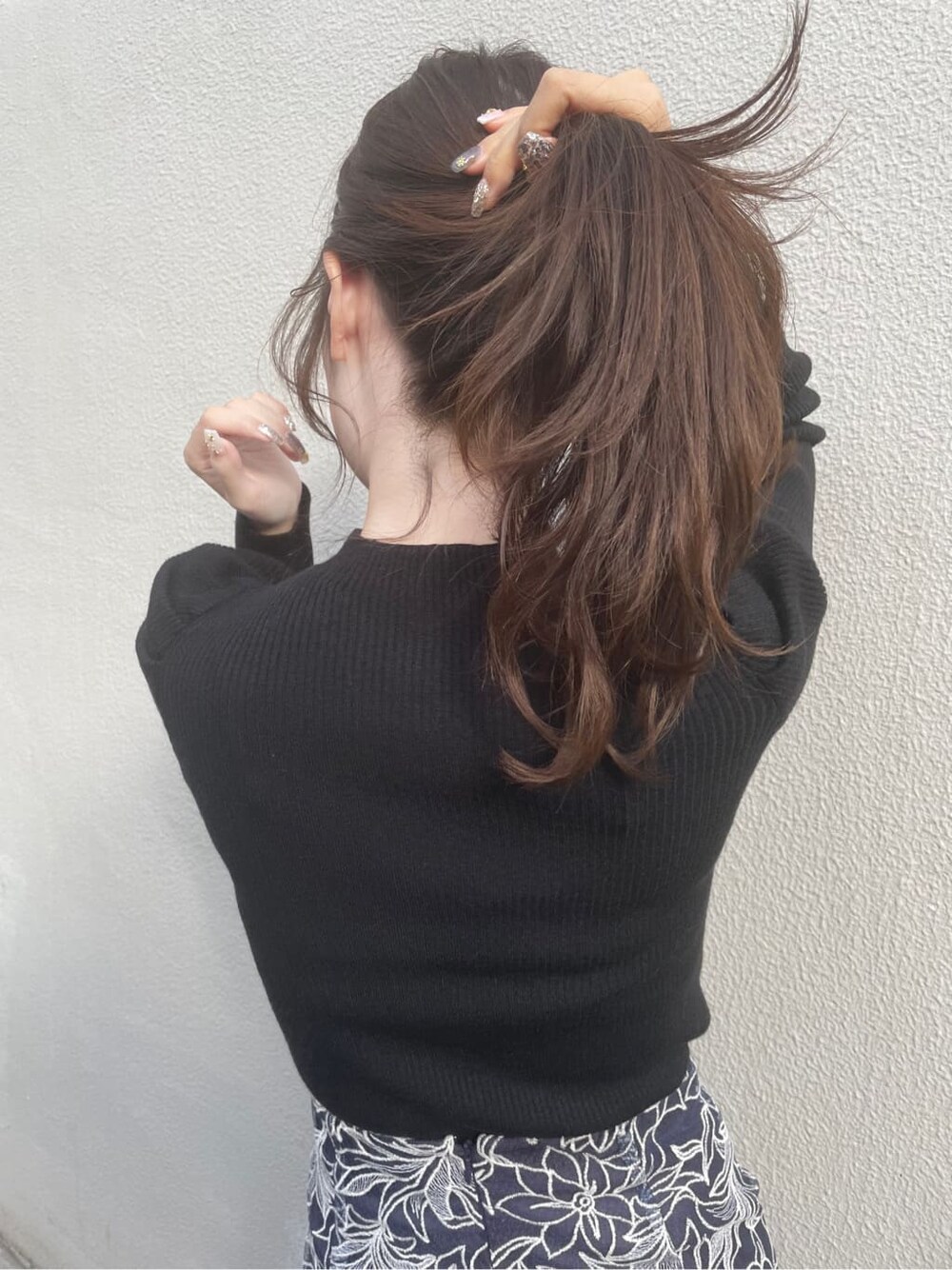 ブラック系のブーツ、ブラック系のニット/セーター、ブルー系のスカートを着用したレディースの冬コーディネートの5枚目の写真