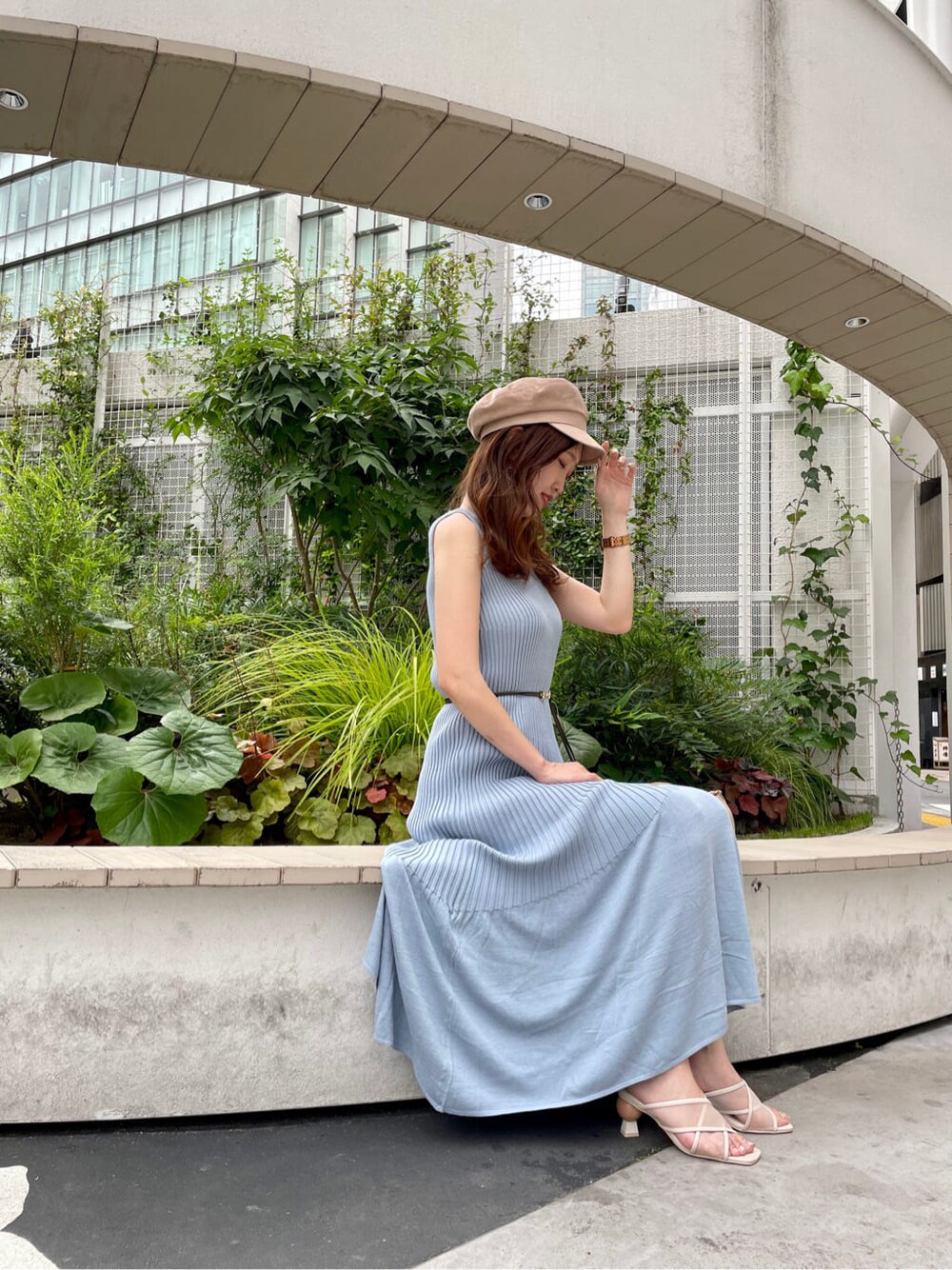 ホワイト系のクラッチバッグ、ブルー系のワンピース、ベージュ系のサンダルを着用したレディースの夏コーディネートの2枚目の写真