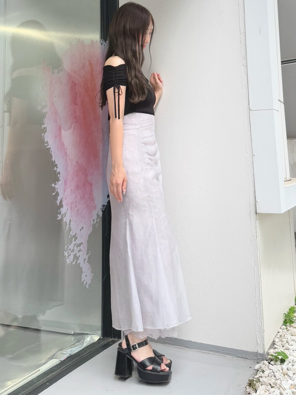 パープル系のスカート、ブラック系のニット/セーター、ブラック系のサンダルを着用したレディースの夏コーディネートの4枚目の写真