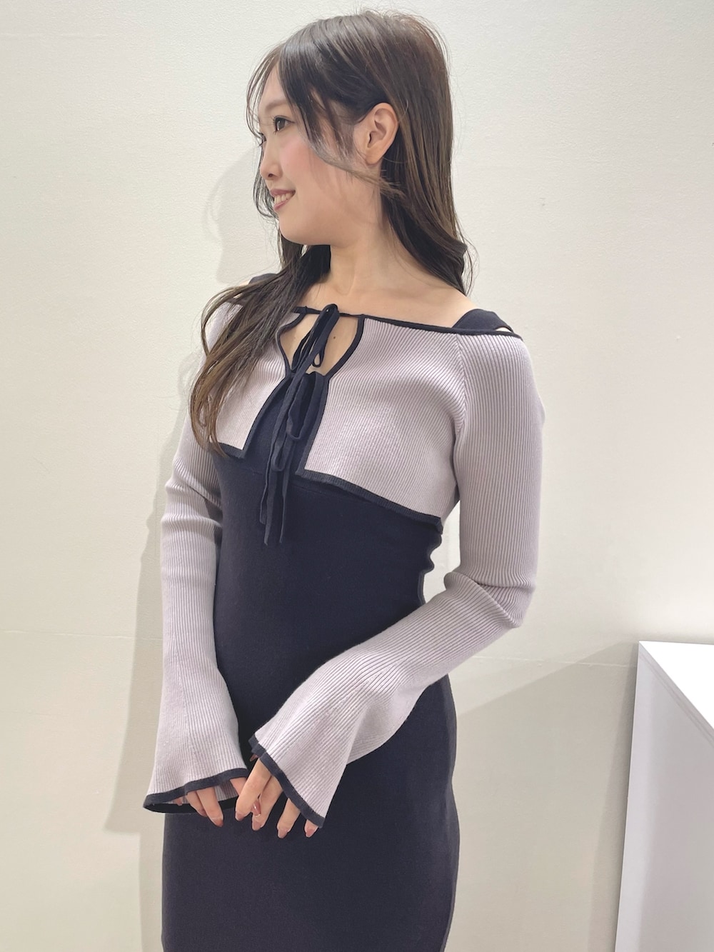 グレー系のワンピース、ブラック系のブーツを着用したレディースの秋コーディネートの4枚目の写真