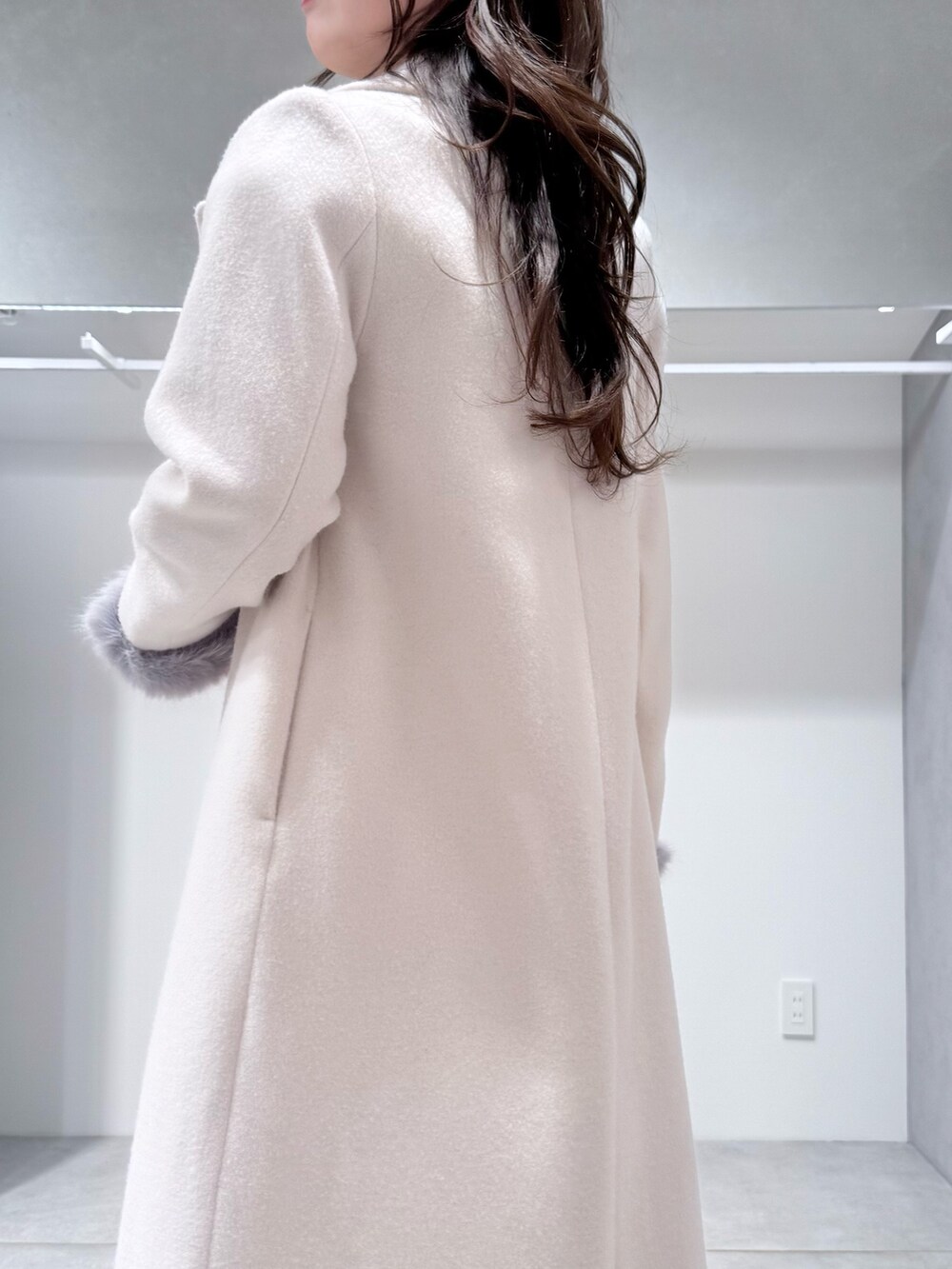 ホワイト系のチェスターコート、ホワイト系のスカート、グレー系のニット/セーターを着用したレディースの冬コーディネートの5枚目の写真