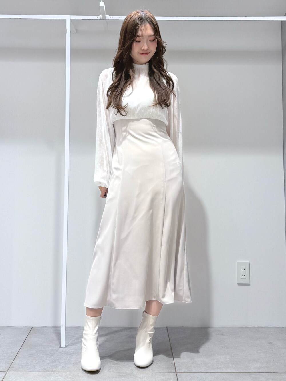 ベージュ系のその他アウター、ホワイト系のワンピース、ホワイト系のブーツを着用したレディースの冬コーディネートの6枚目の写真