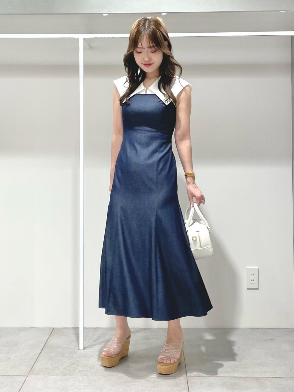 ホワイト系のボストンバッグ、ブルー系のワンピース、その他のサンダルを着用したレディースの春コーディネートの4枚目の写真