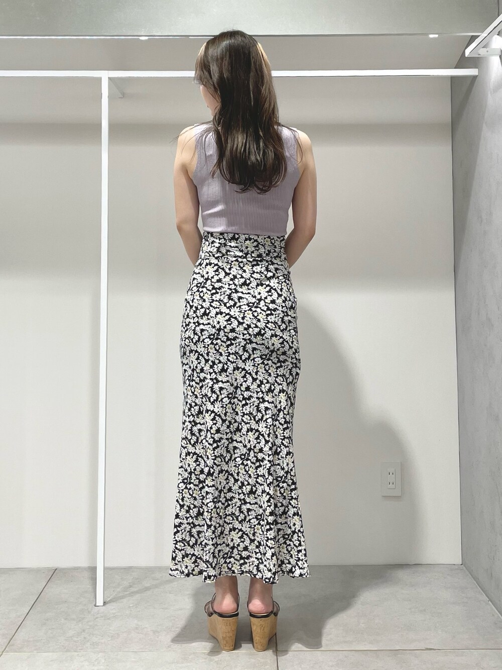 ブラック系のトートバッグ、ブラック系のスカート、ブラック系のサンダルを着用したレディースの夏コーディネートの3枚目の写真