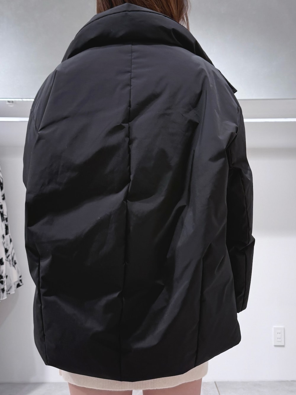 ホワイト系のワンピース、ブラウン系のブーツ、ブラック系のダウンジャケット/コートを着用したレディースの冬コーディネートの6枚目の写真