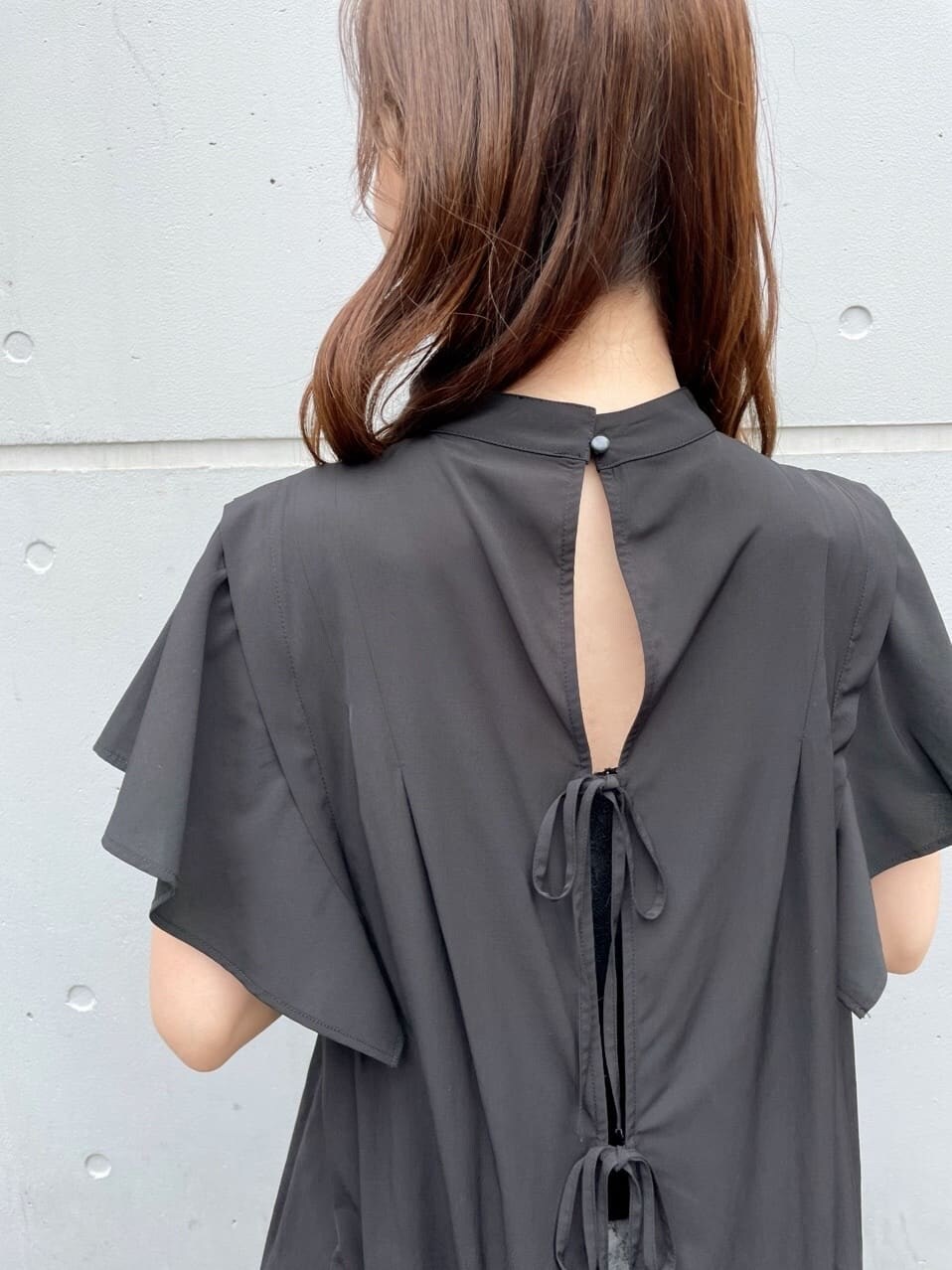 ブラック系のサンダル、ブラック系のシャツ/ブラウス、ホワイト系のクラッチバッグを着用したレディースの夏コーディネートの6枚目の写真