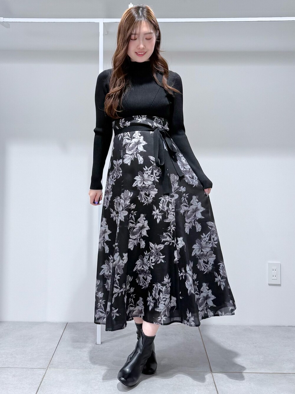 ブラック系のワンピース、ブラック系のブーツを着用したレディースの冬コーディネートの2枚目の写真