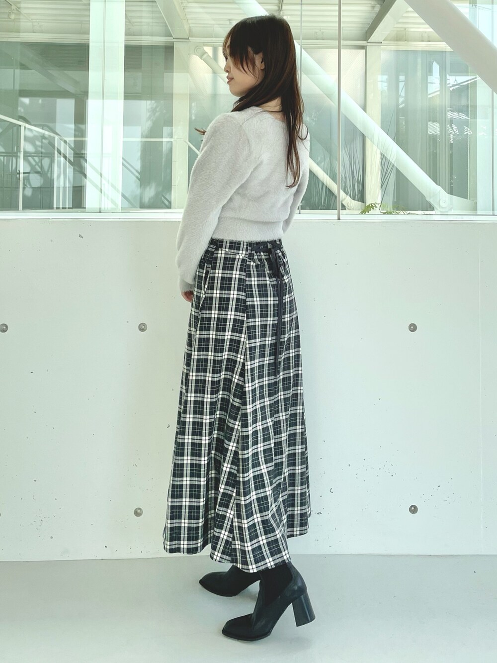 グレー系のカーディガン/ボレロ、ブラック系のスカート、ブラック系のブーツを着用したレディースの秋コーディネートの3枚目の写真