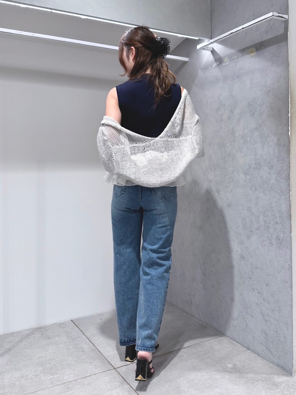 ブルー系のニット/セーター、グレー系のカーディガン/ボレロ、ブルー系のデニムパンツを着用したレディースの夏コーディネートの3枚目の写真
