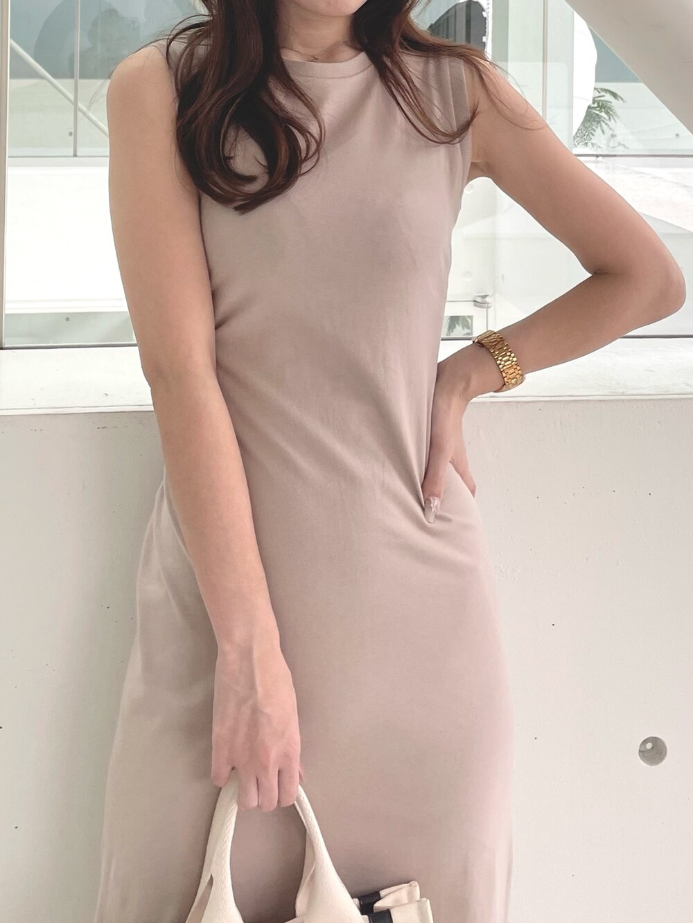 ホワイト系のハンドバッグ、ブラウン系のサンダル、ベージュ系のワンピースを着用したレディースの春コーディネートの5枚目の写真