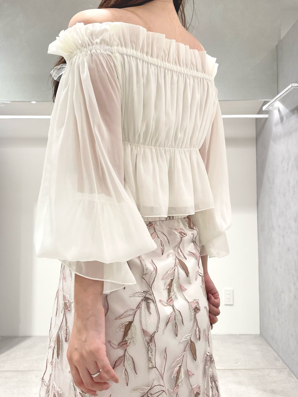 ホワイト系のシャツ/ブラウス、ピンク系のスカート、ベージュ系のパンプスを着用したレディースの夏コーディネートの7枚目の写真