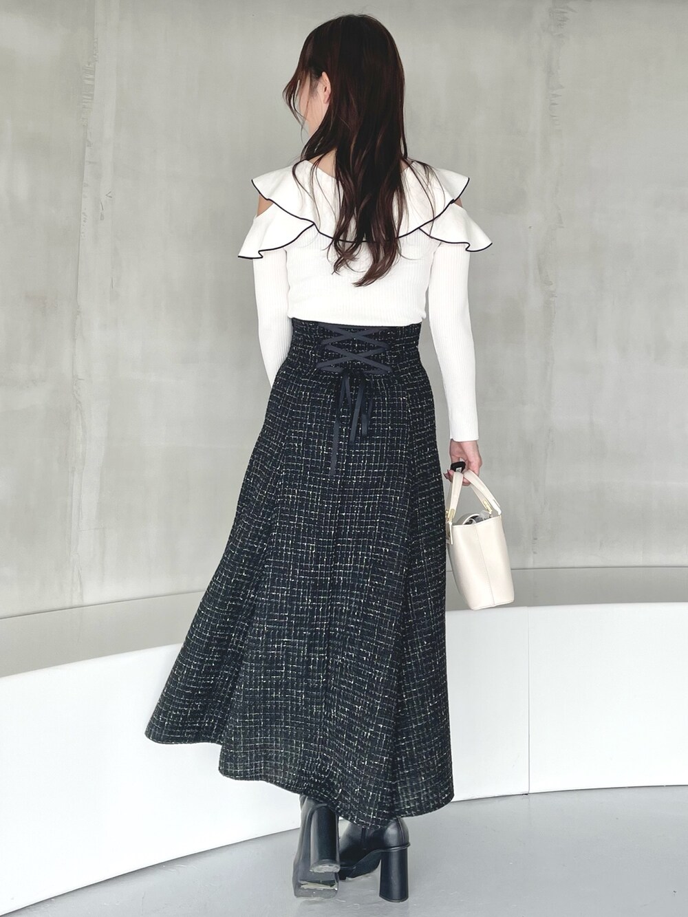 その他のニット/セーター、ブラック系のスカート、ホワイト系のハンドバッグを着用したレディースの秋コーディネートの4枚目の写真