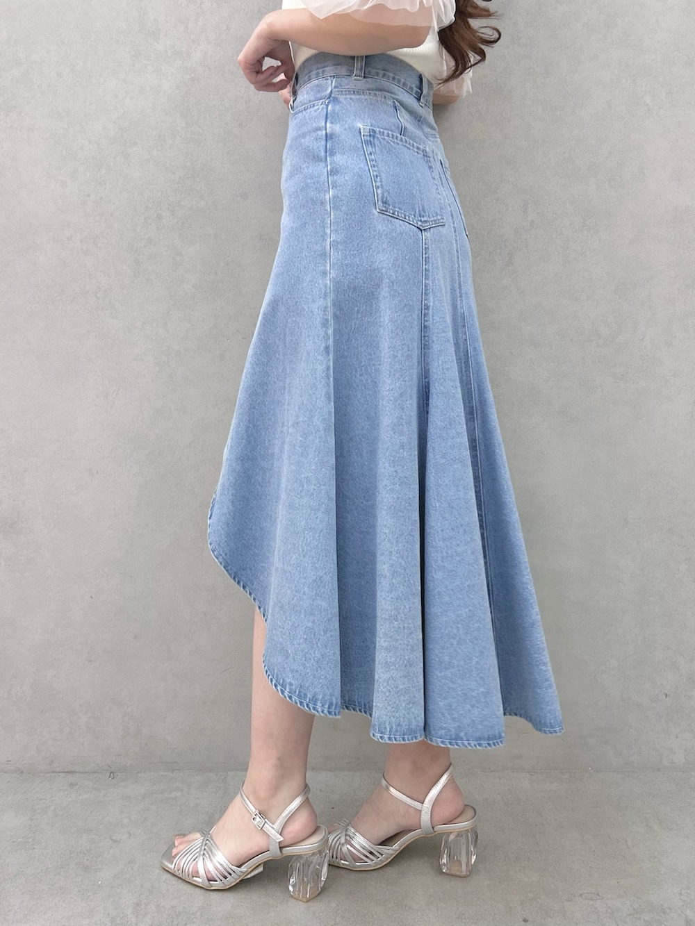 ホワイト系のニット/セーター、ブルー系のスカート、シルバー系のサンダルを着用したレディースの春コーディネートの8枚目の写真