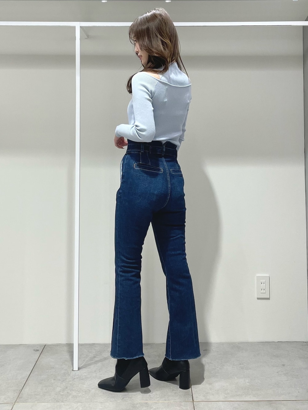 ホワイト系のハンドバッグ、ブラック系のブーツ、ブルー系のニット/セーターを着用したレディースの冬コーディネートの8枚目の写真