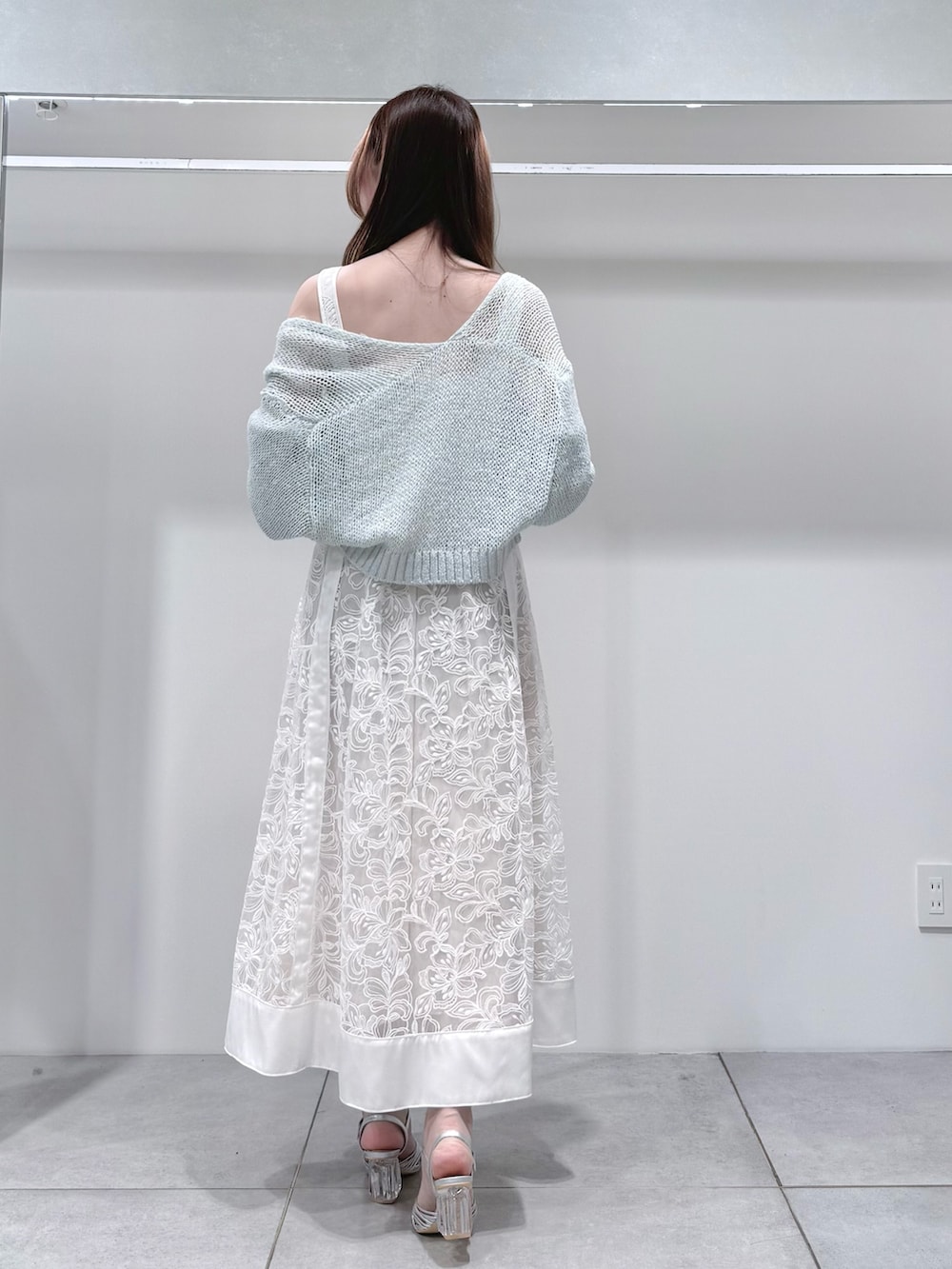 ブルー系のカーディガン/ボレロ、ホワイト系のワンピース、シルバー系のサンダルを着用したレディースの春コーディネートの4枚目の写真