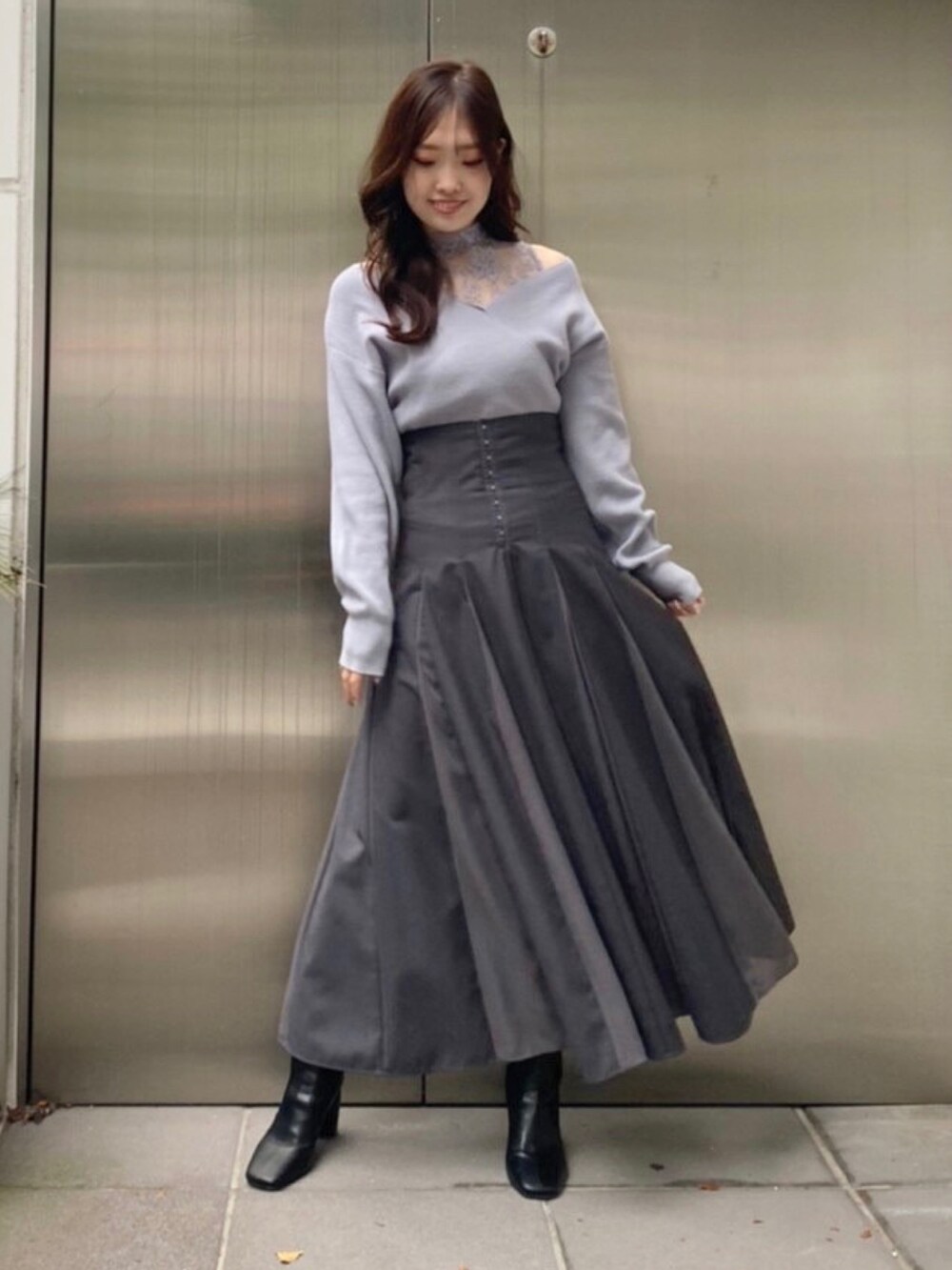 ホワイト系のダウンジャケット/コート、ブルー系のニット/セーター、グレー系のスカートを着用したレディースの秋コーディネートの5枚目の写真