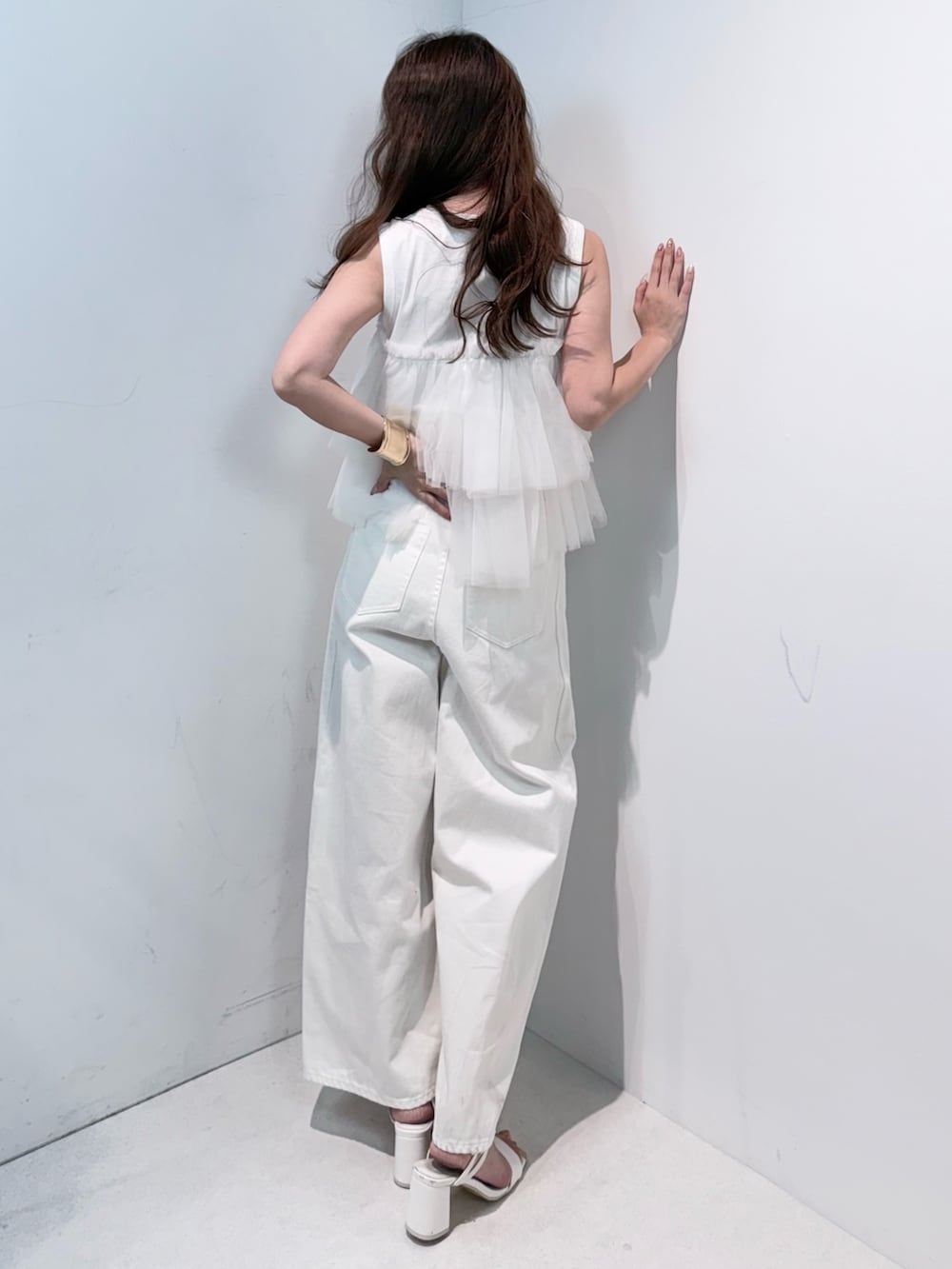 ホワイト系のデニムパンツ、ホワイト系のサンダル、ホワイト系のTシャツ/カットソーを着用したレディースの春コーディネートの3枚目の写真