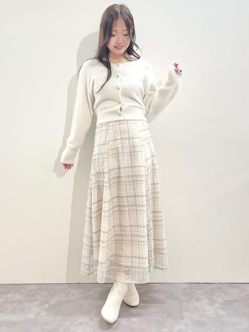 ホワイト系のその他アウター、ホワイト系のスカート、ホワイト系のブーツを着用したレディースの冬コーディネートの3枚目の写真