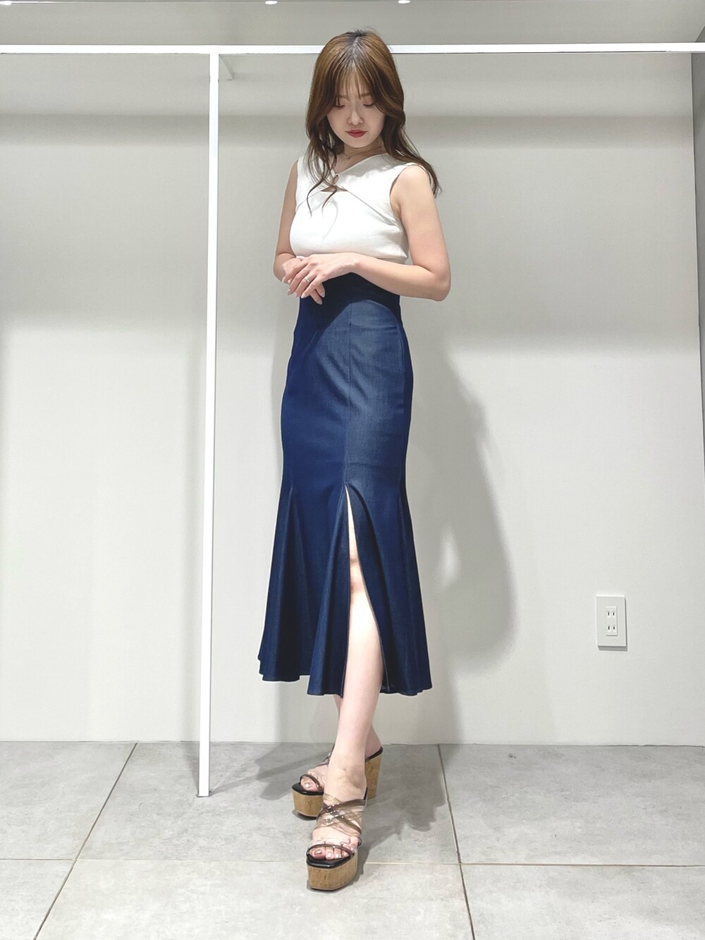 ブルー系のスカート、ブラック系のサンダル、ベージュ系のシャツ/ブラウスを着用したレディースの春コーディネートの9枚目の写真