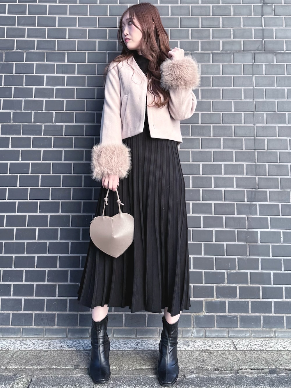 ブラック系のブーツ、ブラック系のワンピース、ベージュ系のショルダーバッグを着用したレディースの冬コーディネートの2枚目の写真