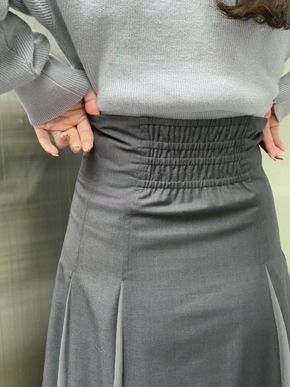 ホワイト系のダウンジャケット/コート、ブルー系のニット/セーター、グレー系のスカートを着用したレディースの秋コーディネートの9枚目の写真