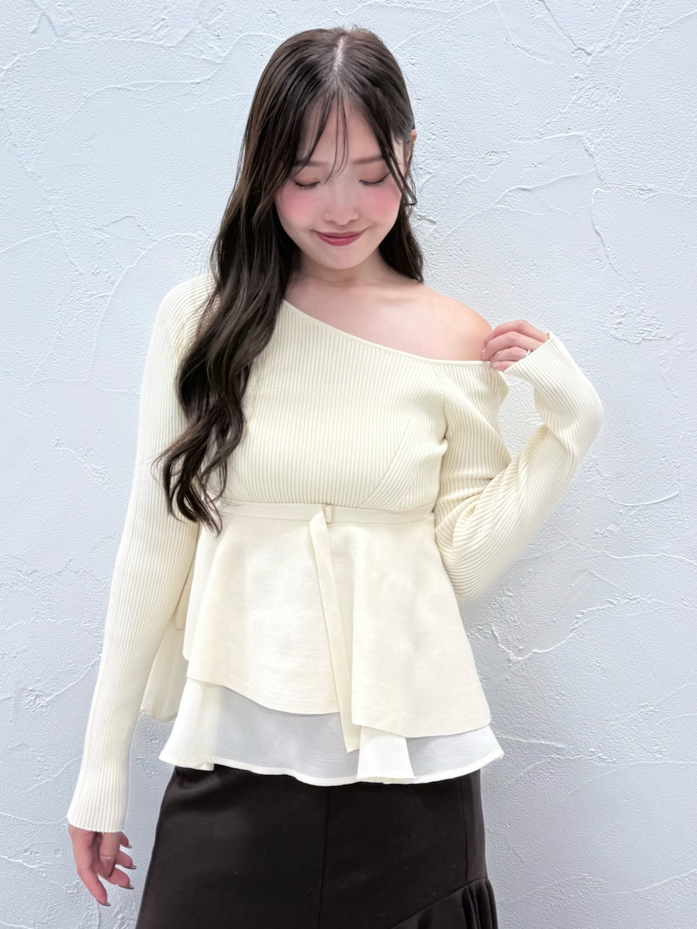 ホワイト系のニット/セーター、ブラウン系のスカート、ブラウン系のブーツを着用したレディースの秋コーディネートの4枚目の写真