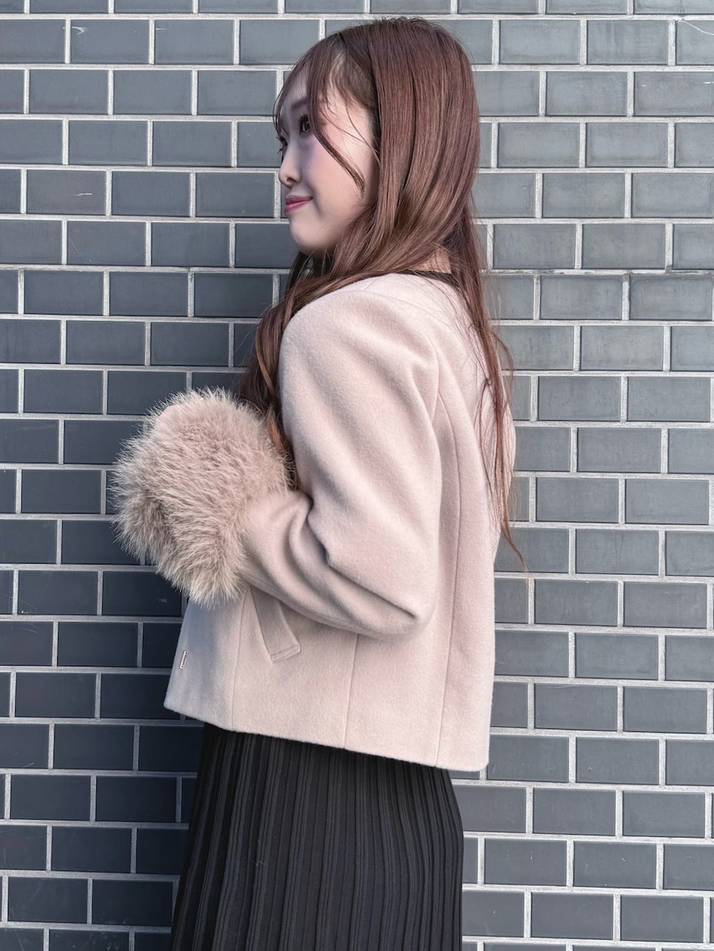 ブラック系のブーツ、ブラック系のワンピース、ベージュ系のショルダーバッグを着用したレディースの冬コーディネートの6枚目の写真