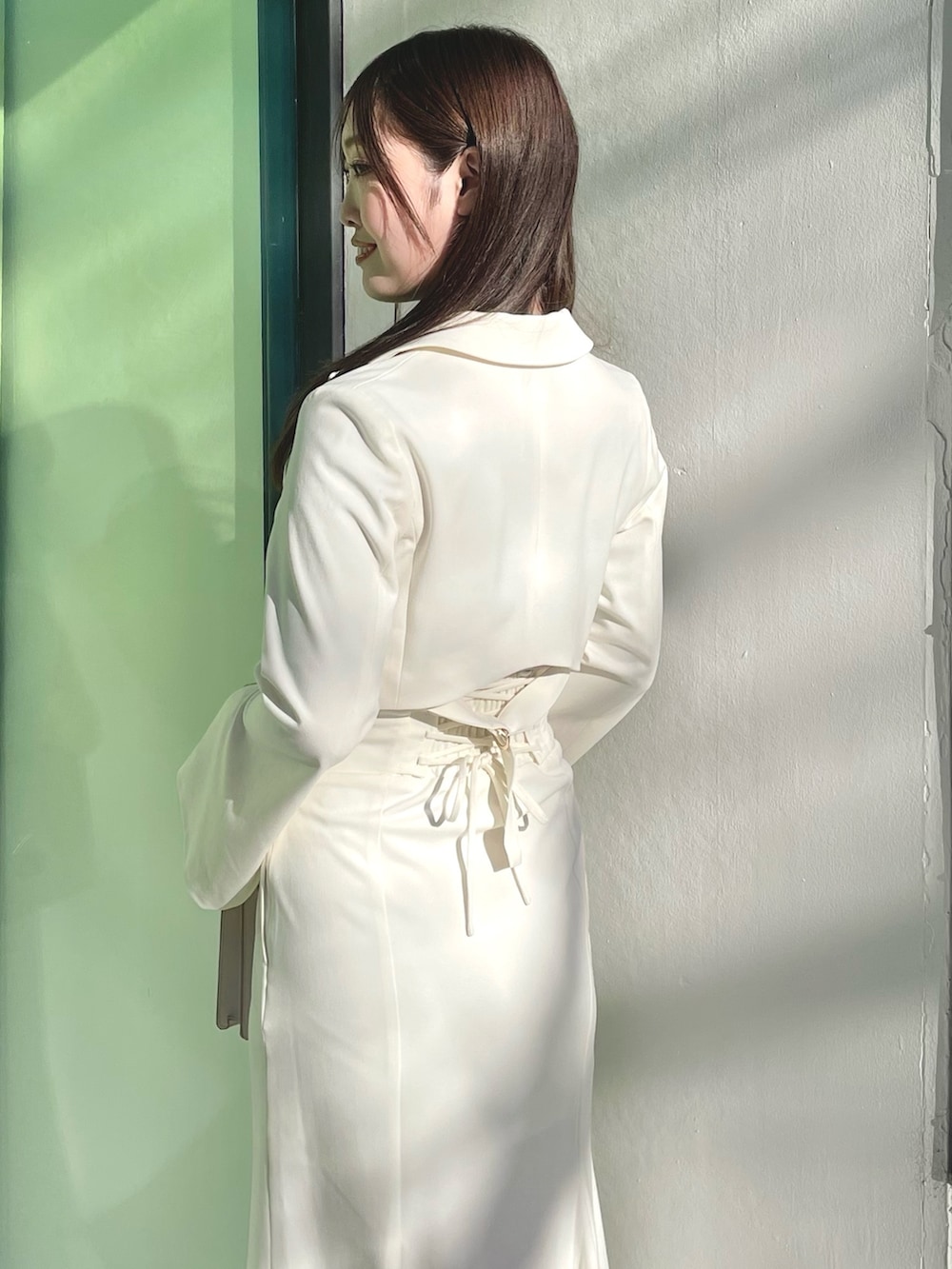 ピンク系のニット/セーター、ホワイト系のテーラードジャケット、ホワイト系のスカートを着用したレディースの春コーディネートの5枚目の写真