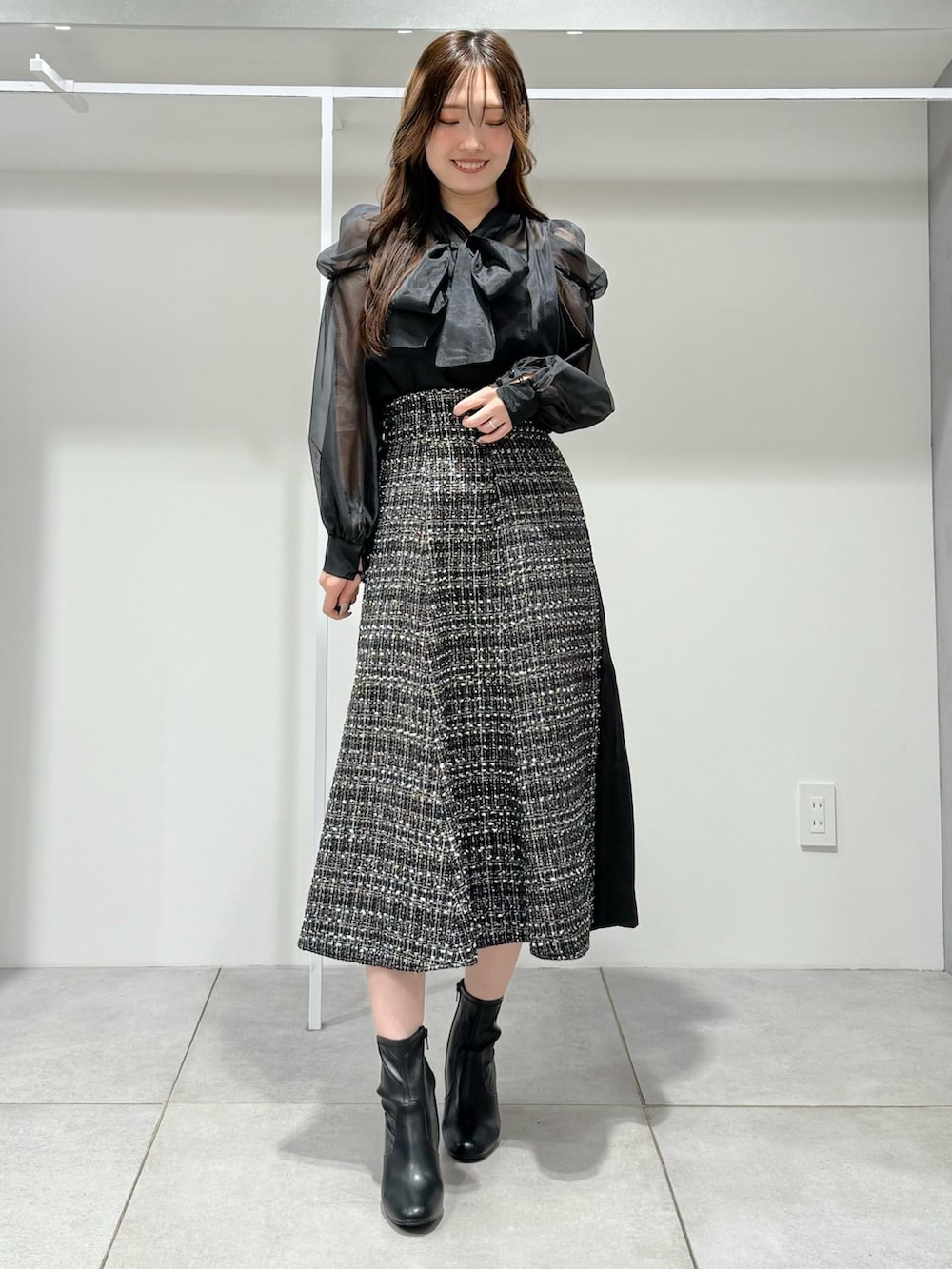 ブラック系のテーラードジャケット、ブラック系のスカート、ブラック系のシャツ/ブラウスを着用したレディースの秋コーディネートの6枚目の写真
