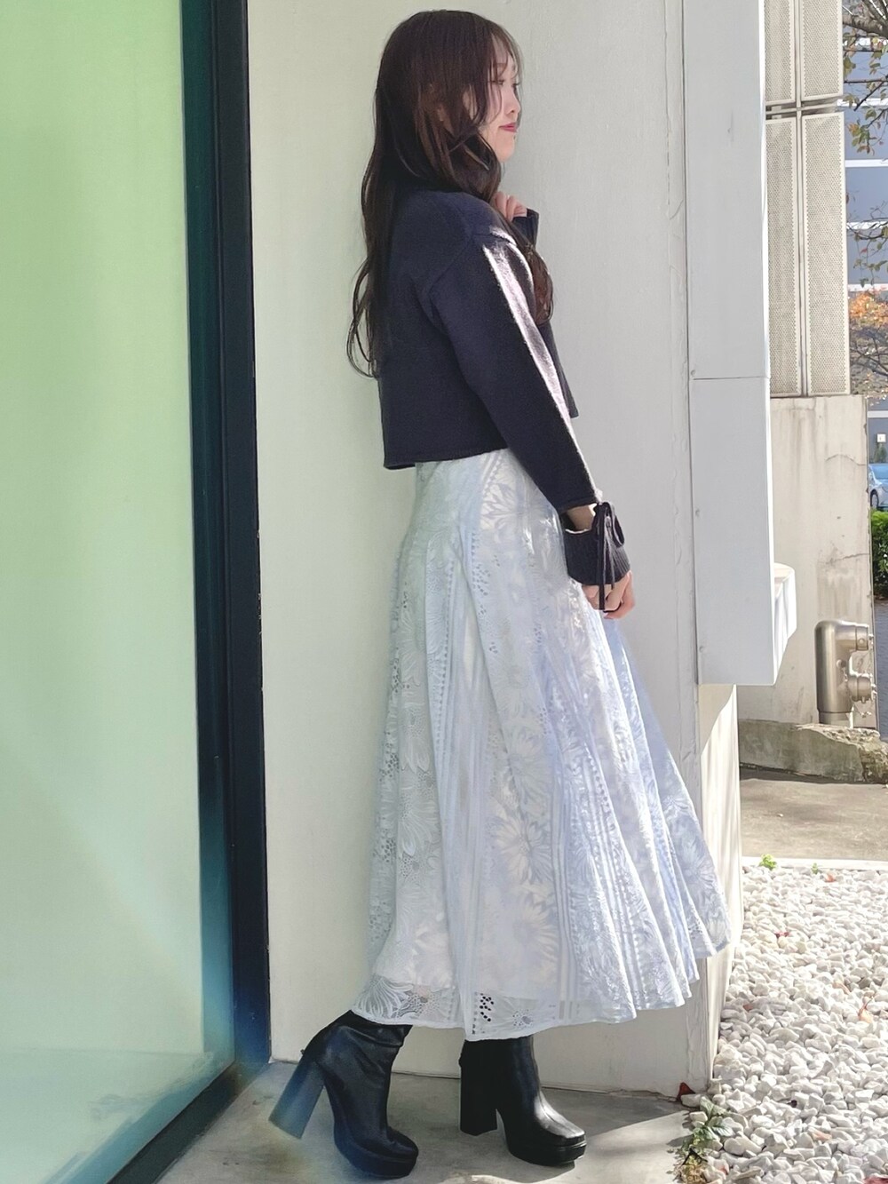 ブルー系のスカート、グレー系のニット/セーター、ブラック系のブーツを着用したレディースの冬コーディネートの4枚目の写真