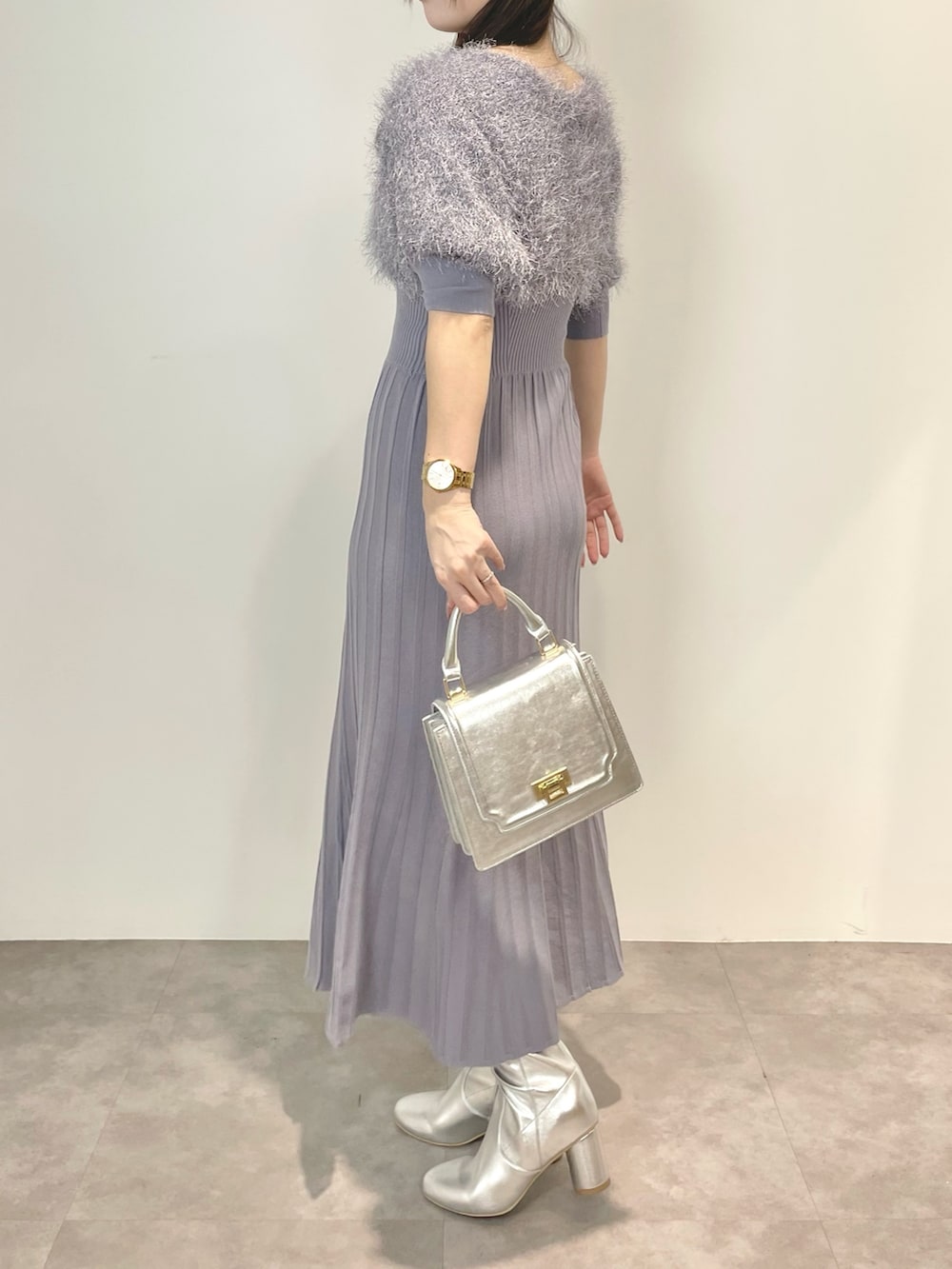 ブルー系のワンピース、シルバー系のハンドバッグ、シルバー系のブーツを着用したレディースの冬コーディネートの3枚目の写真