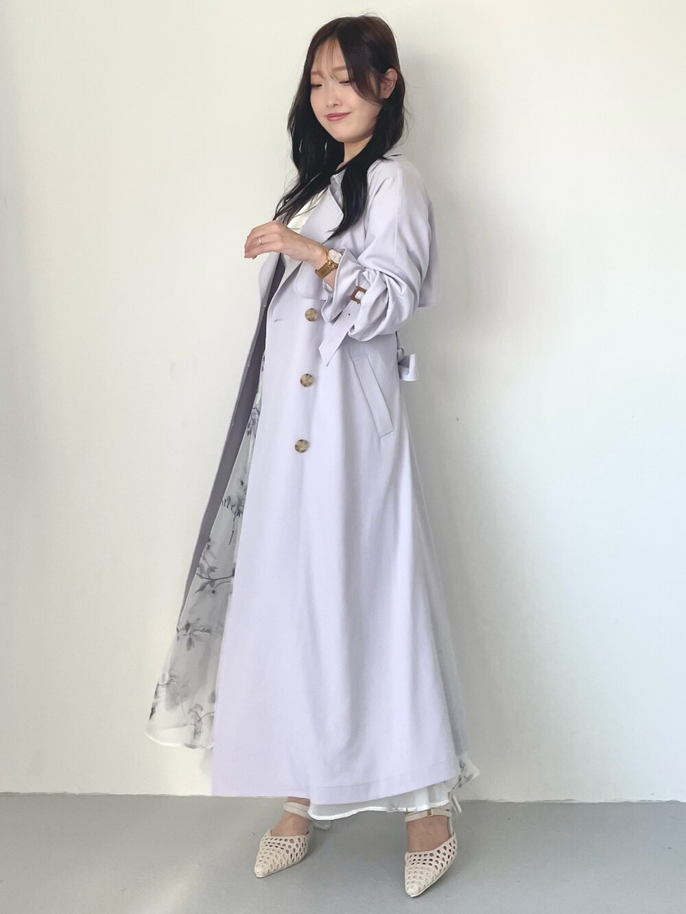 ホワイト系のスカート、パープル系のトレンチコート、ホワイト系のニット/セーターを着用したレディースの冬コーディネートの3枚目の写真