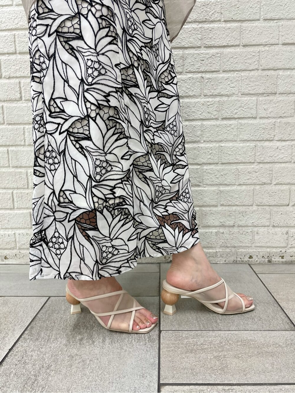 ベージュ系のサンダル、ブラック系のワンピース、ベージュ系のシャツ/ブラウスを着用したレディースの夏コーディネートの6枚目の写真