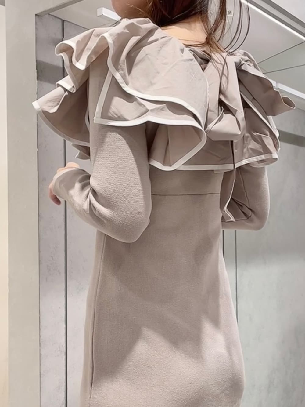 ベージュ系のワンピース、ホワイト系のブーツを着用したレディースの秋コーディネートの5枚目の写真