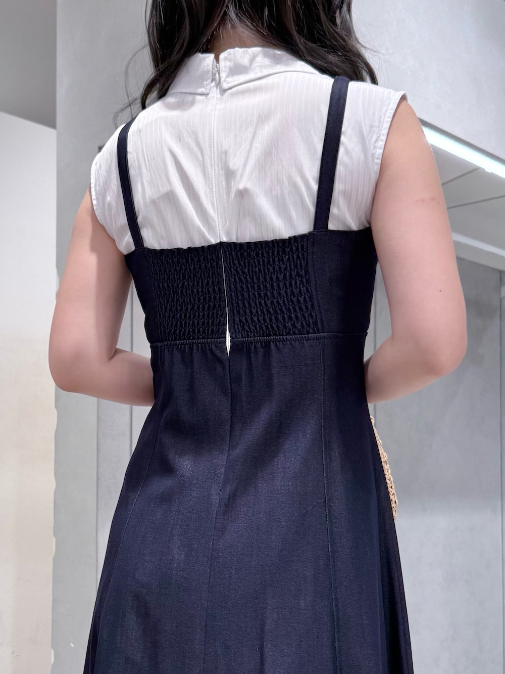 ブルー系のワンピース、ベージュ系のハンドバッグ、ホワイト系のサンダルを着用したレディースの夏コーディネートの6枚目の写真