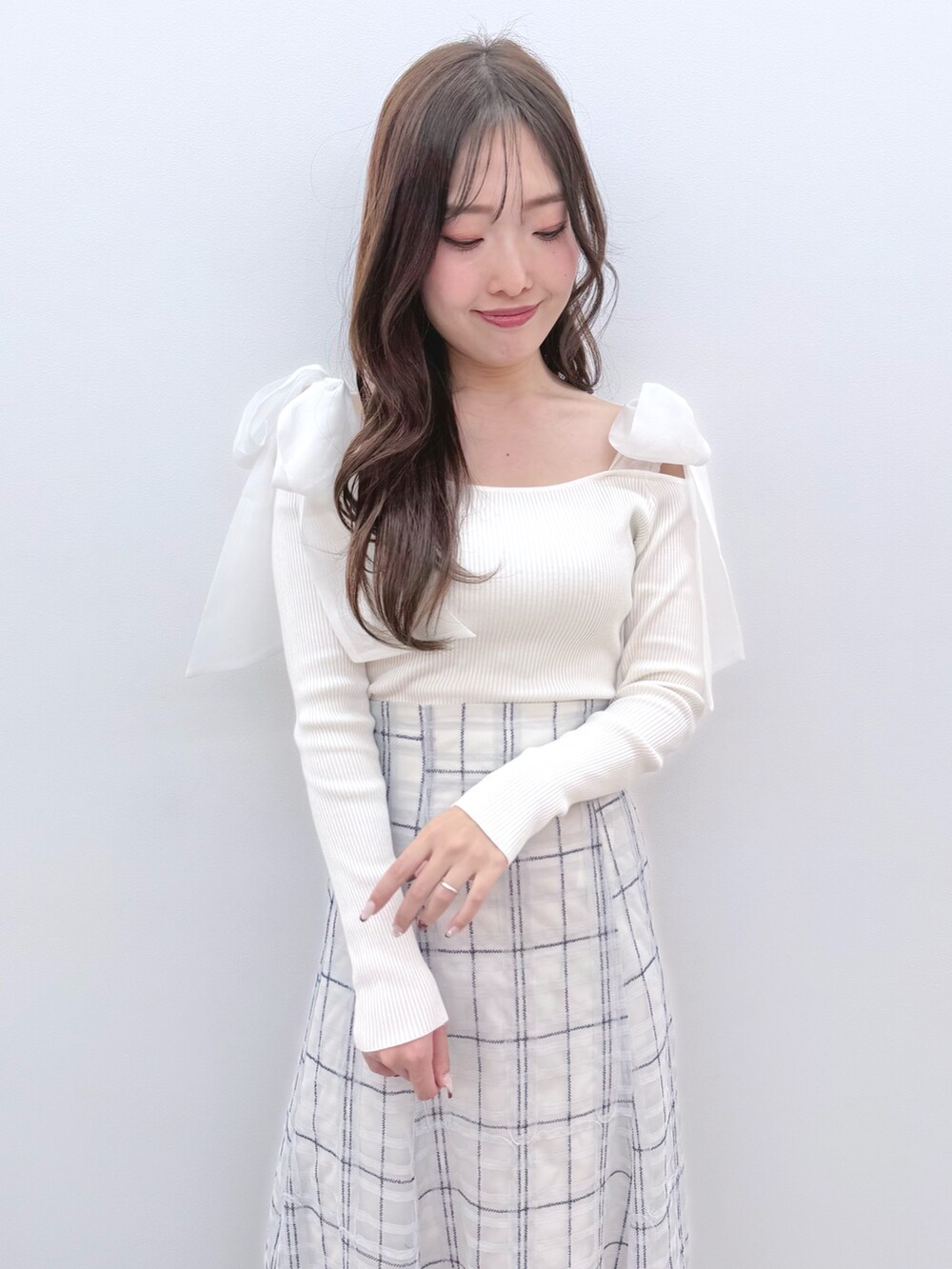 ホワイト系のニット/セーター、ブルー系のスカート、ホワイト系のブーツを着用したレディースの冬コーディネートの5枚目の写真