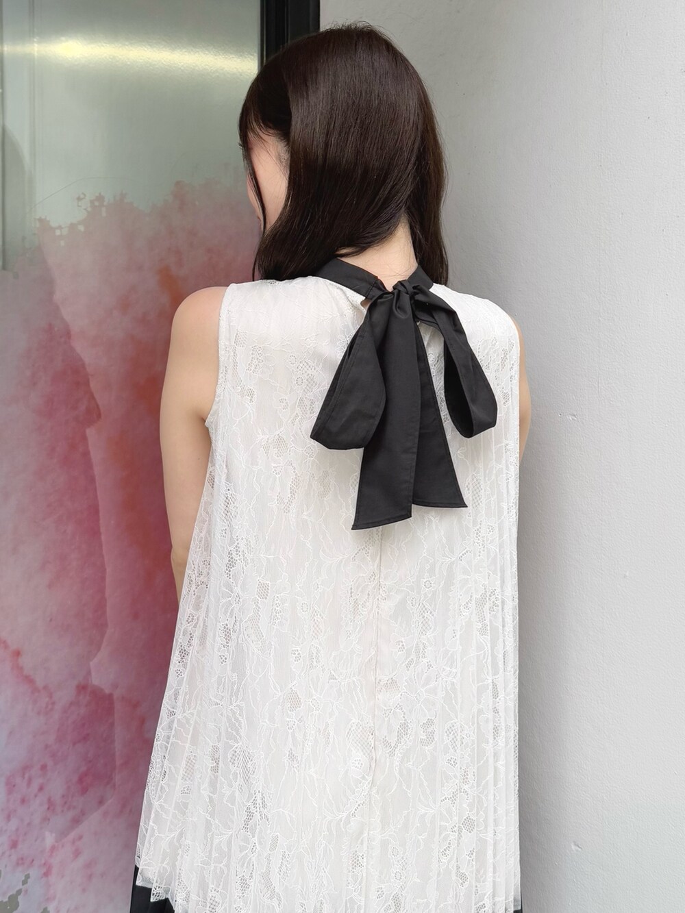 ホワイト系のワンピース、ブラック系のハンドバッグ、ブラック系のサンダルを着用したレディースの夏コーディネートの7枚目の写真