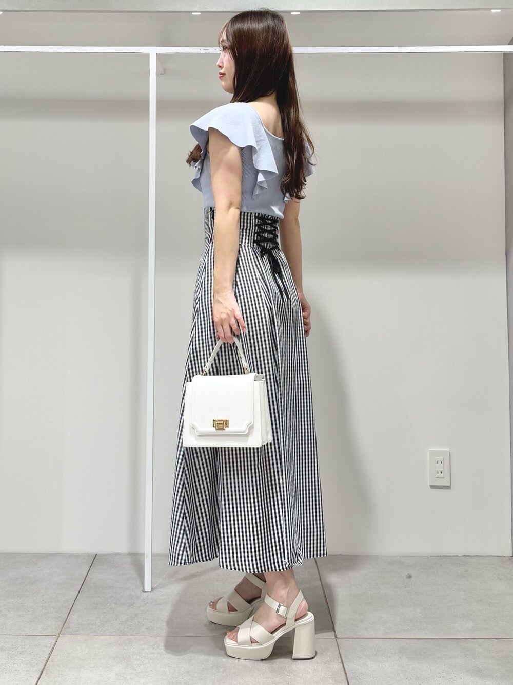 ブルー系のニット/セーター、その他のスカート、ホワイト系のサンダルを着用したレディースの春コーディネートの3枚目の写真