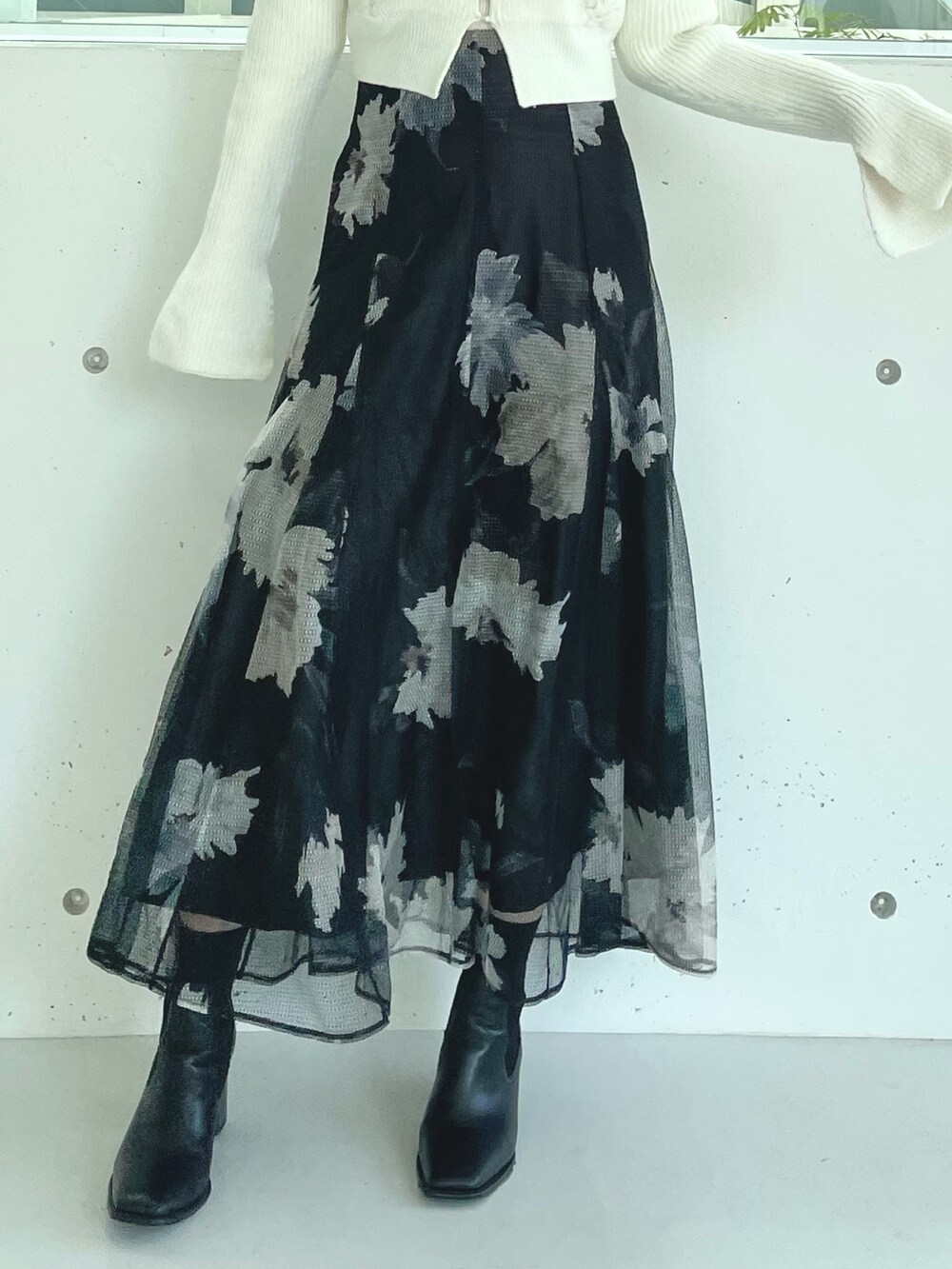 ブラック系のスカート、ブラック系のブーツ、ホワイト系のカーディガン/ボレロを着用したレディースの秋コーディネートの7枚目の写真