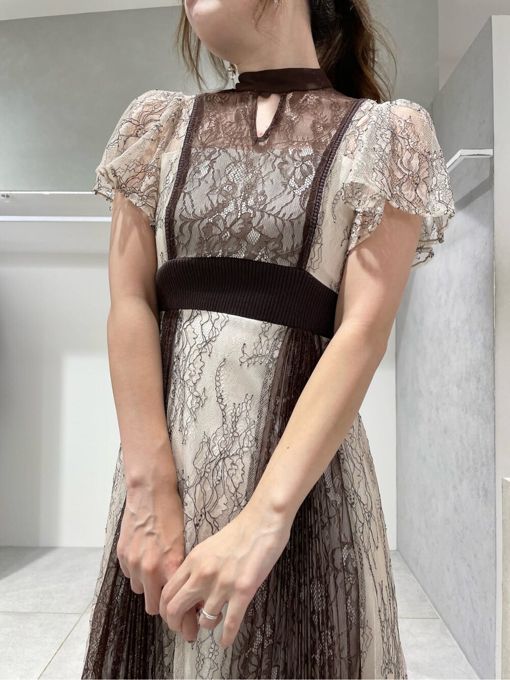 ブラック系のパンプス、ホワイト系のワンピース、ベージュ系のカーディガン/ボレロを着用したレディースの秋コーディネートの7枚目の写真