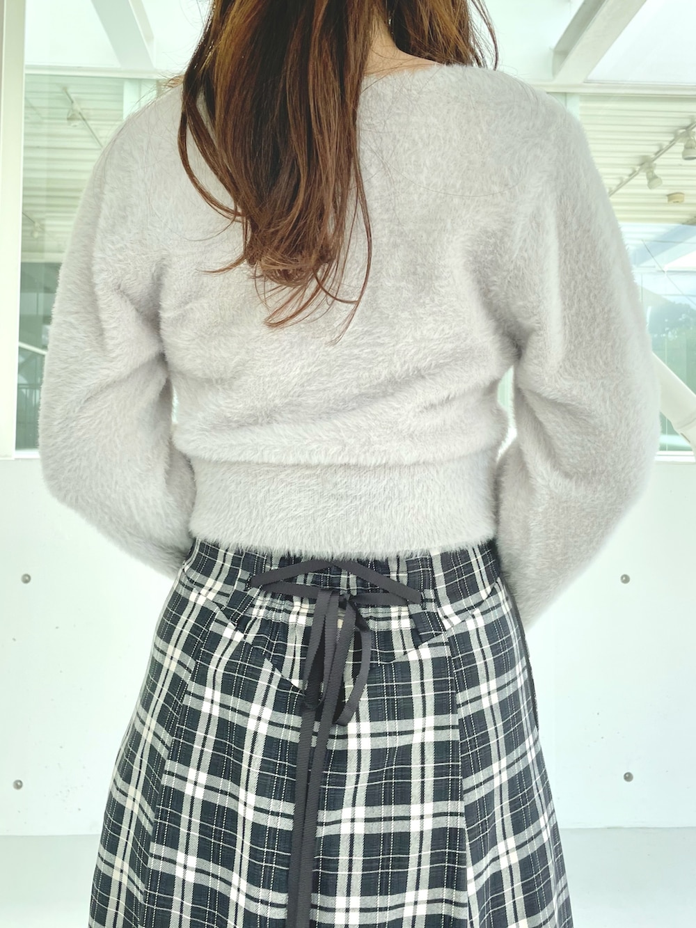 グレー系のカーディガン/ボレロ、ブラック系のスカート、ブラック系のブーツを着用したレディースの秋コーディネートの6枚目の写真