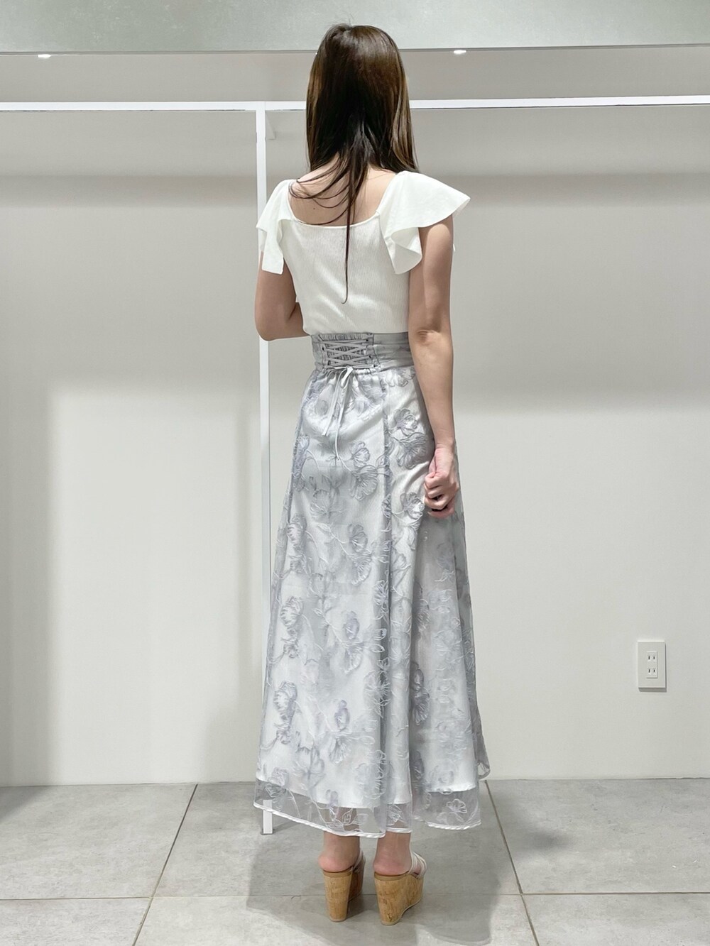 ホワイト系のニット/セーター、ブルー系のスカート、その他のサンダルを着用したレディースの春コーディネートの4枚目の写真