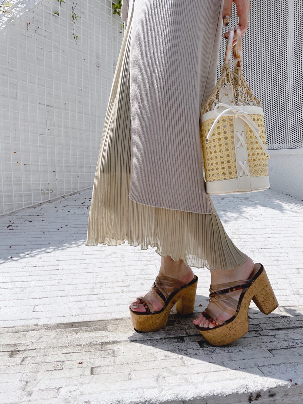 ホワイト系のハンドバッグ、ホワイト系のキャミソール、ベージュ系のサンダルを着用したレディースの夏コーディネートの4枚目の写真