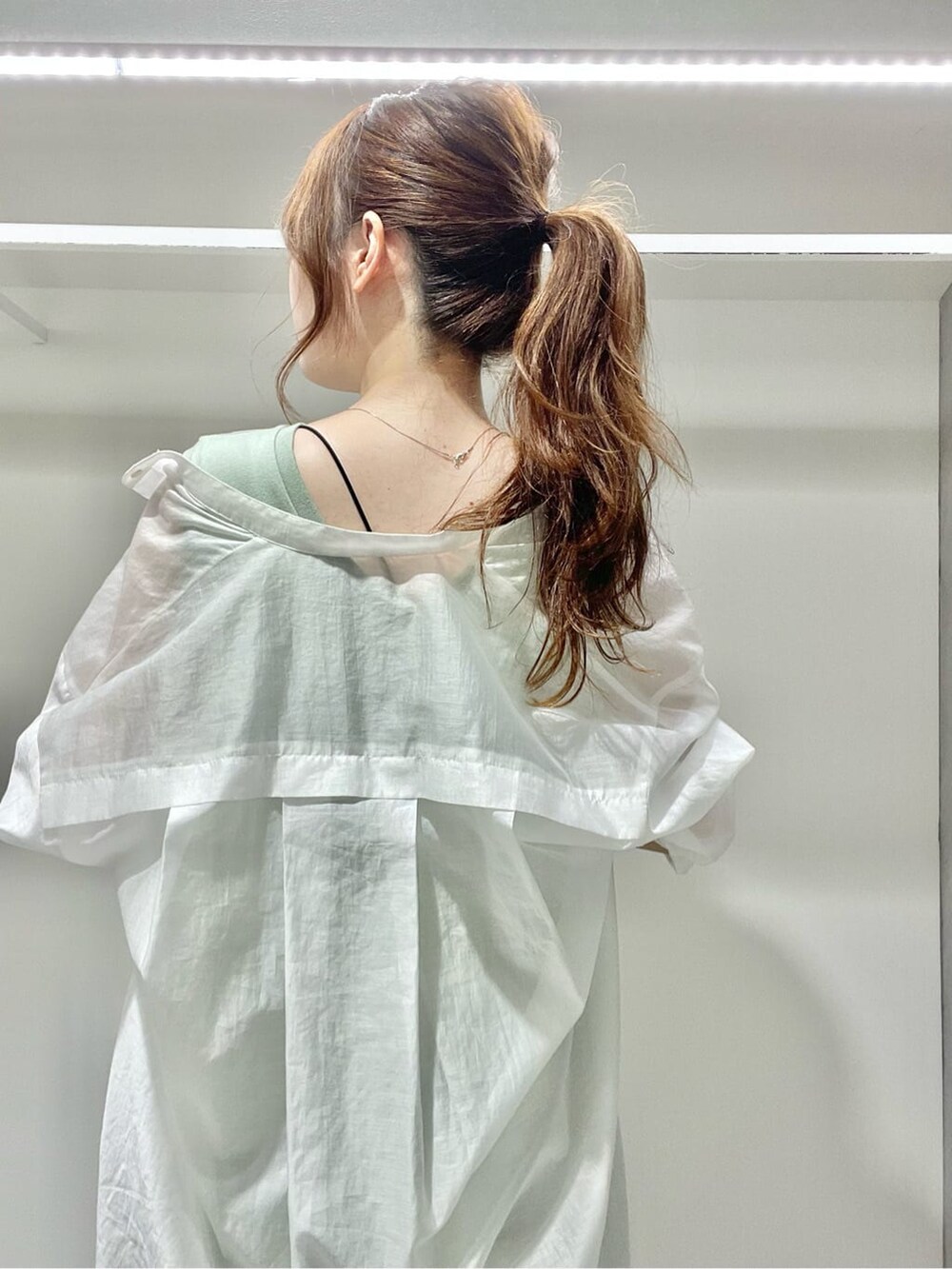 グリーン系のサンダル、ホワイト系のシャツ/ブラウス、ブラック系のキャミソールを着用したレディースの夏コーディネートの4枚目の写真