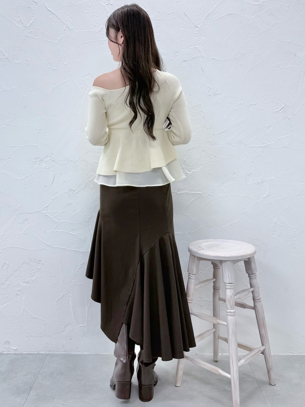 ホワイト系のニット/セーター、ブラウン系のスカート、ブラウン系のブーツを着用したレディースの秋コーディネートの3枚目の写真